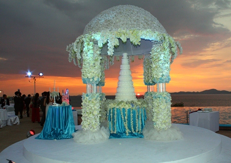A beautiful sunset provides the backdrop for the virgin wedding cake.