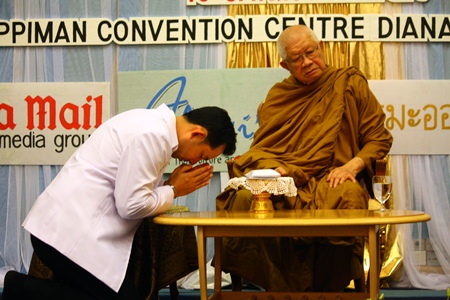 Mayor Itthiphol presents the donations from the evening function to Phra Dhammamongkolyarn.