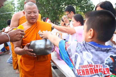 Abbot Pisan Jariyaphiwat leads more than 50 monks to accept alms from large groups of worshippers at Chaimongkol Temple in South Pattaya. 
