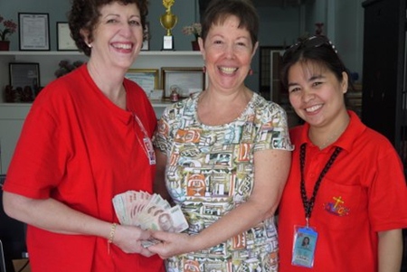 Judith hands the generously donated money to Francesca and Leng Leng at the Mercy Centre. 