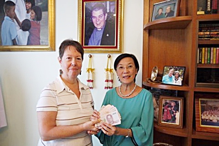Judith hands the money donated by PCEC members to Toy at the Pattaya Orphanage. 