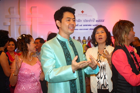 Chonburi MP Poramet Ngampichet, wearing a handsome Thai outfit that he modeled in the fashion show, dances with guests.