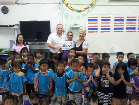 Event organisers Eva Johnson and Earl Brown present a record amount of 76,400 baht to the Hand to Hand Foundation following November’s 1st anniversary party.