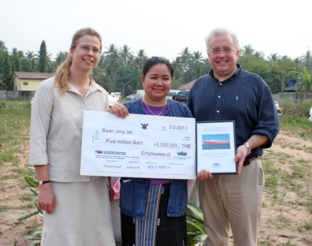 Piangta Chumnoi holds the 5 million baht cheque that was presented to her by Trond Tønjum and Jesse Linde of Wallenius Wilhelmsen Logistics.