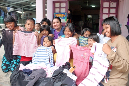 Children are thrilled with the gift of new clothing brought by their benefactors.