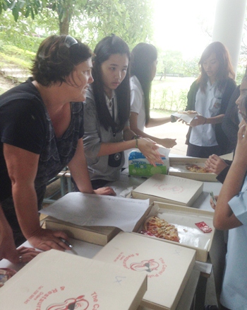 IB CAS coordinator Ms Morris helps students dish out the pizza.