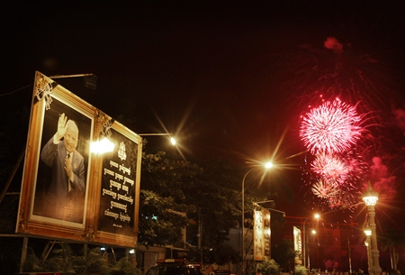 Fireworks explode next to a poster of Cambodia’s former King Norodom Sihanouk as his body is cremated in Phnom Penh. (AP Photo/Wong Maye-E)