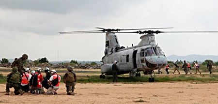 Evacuees are led to a U.S. Marine Corps CH-46E Sea Knight helicopter while conducting a multinational emergency evacuation drill Feb. 17 in Pattaya, during exercise Cobra Gold 2013. Military members from Thailand, Japan, Indonesia, and Malaysia worked alongside U.S. Marines and sailors of the 31st Marine Expeditionary Unit to process multinational citizens through security and screening stations before evacuating them via helicopter. (130217-M-IM838-096)