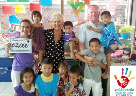 Pattaya Soul Club founders Earl Brown and Eva Johnson (standing rear center) present a cheque for 62,000 baht, money raised from the March Soul Night, to representatives and children at the Hand to Hand Foundation in Pattaya.