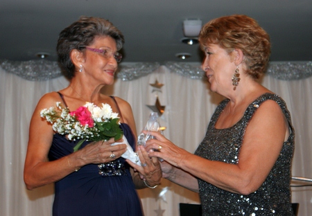 Founding member Pat Burbridge (left) receives a token of appreciation from Ann Winfield.