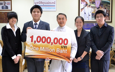 Father Peter accepts the cheque from the Bangkok students.
