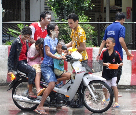 Four people on a single motorcycle, including 3 children, and not one person wearing a helmet - all making for a good example of what NOT to do during the Songkran holidays.
