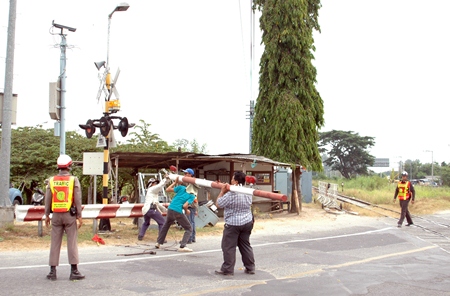 City workers repair the train-crossing gate damaged by a speeding car on Soi Siam Country Club.