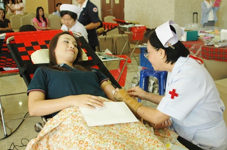Nurse Kotchakorn Auamsamang (right), chief of the blood donation unit at Sriracha’s Ratchathewi Hospital, Sriracha, attends to a donor.