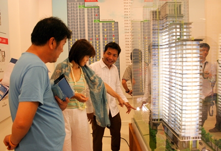 Chisanucha Pakdeesaneha, CEO of Porch Land Group, (right) outlines details of the project to potential customers. 
