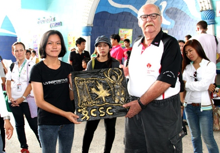 Nong (center) presents a plaque of appreciation she made to Wayne Ogonoski representing the Canadian Jackalope Open.