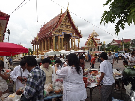 At Wat Nongyai, citizens purchase food to present as alms.