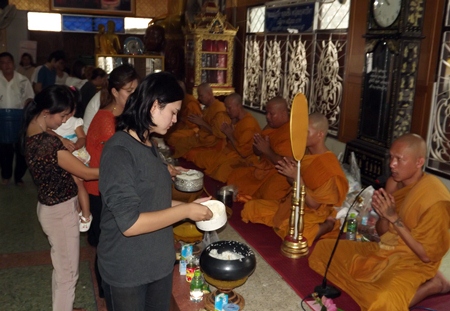 Faithful Buddhists offer alms and make merit on Visakha Bucha Day at Wat Nongyai.