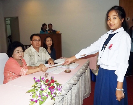 Mrs. Wanthanee Supornsahatrangsi (left), assistant MD of Sunshine hotels and resorts, presents 2,000 baht scholarships to children in Prathom 1-6.
