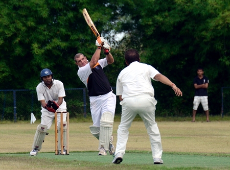 Pattaya Cricket Club’s Simon Philbrook (center) hits out against the Champions bowling attack during the Bangkok Cricket League semi-final at Thai Polo Club in Pattaya, Sunday, May 19.