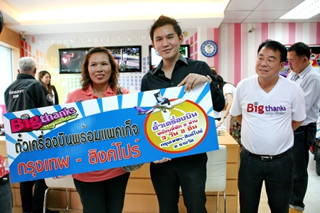 Mrs. Lamyai Thupwan (left) accepts the award from Rattakit Hengtrakul, deputy MD of Sophon Cable TV Pattaya, winning tickets from Bangkok to Singapore for 3 days and 2 nights.