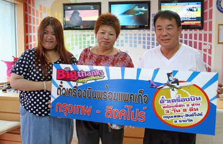 Malee Panchai (2nd left), the second lucky winner who won air tickets from Bangkok to Singapore for 3 days and 2 nights, receives her prize from Suwat Rachotwattanakul (right), deputy MD of Sophon Cable TV Pattaya.