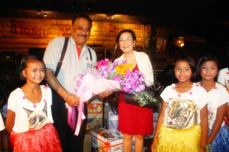 Aunty Toy (right) and children from the CPDC center present flowers to Peter.