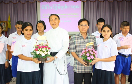 Student representatives from the Redemptorist School for the Blind present hand-made flowers to thank Father Pattarapong Srivorakul and Supamit Sirakantamakul.