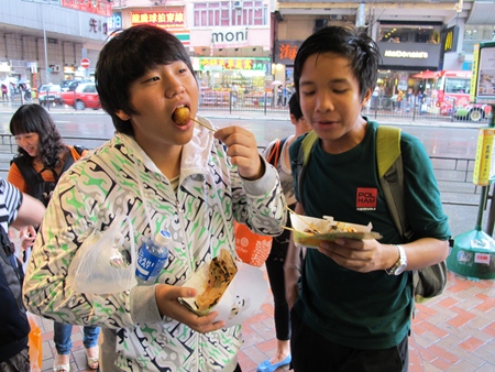 This tastes good! A Year 9 student samples some Hong Kong food.