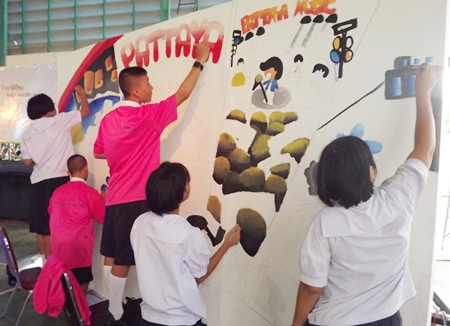 Students painting on the ‘white wall’.