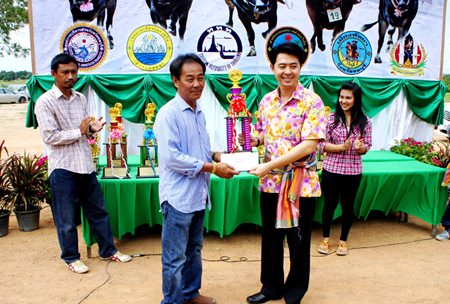 Chonburi MP Poramet Ngampichet (right) presents the winning trophy and 5,000 baht to Sheriff Suwit (left), owner of Buffalo no. 1 that won the Special Junior category.