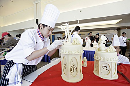 This chef is concentrating hard whilst decorating a cake in the Wedding Cake decoration contest.