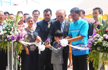 Chao Jiramongkol (center) and family, along with Chonburi Permanent Secretary Chaowalit Saeng-Uthai (2nd from right), cut the ribbon to open the new Chao Jiramongkol building at Banglamung Hospital.