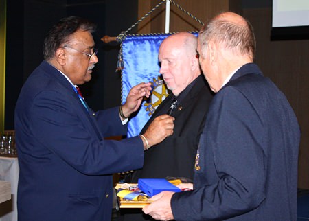 (L to R) Rotary District 3340 Past Gov. Peter Malhotra (left) pins the honorary Rotary badge on Reiner Calmund’s jacket, as Club President Dr. Otmar Deter looks on.