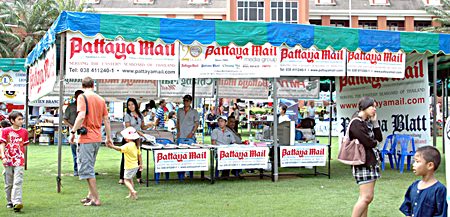 Staff from Pattaya Mail Publishing Co. Ltd., a sponsor since the first charity drive, hand out free newspapers at the fair.