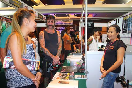 Interested people visit one of the booths at the 3rd Pattaya International Tattoo Convention at the Hard Rock Hotel.