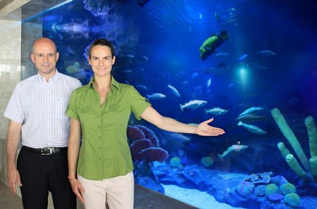 Dominique Ronge (left) stands with the hotel’s professional aquarium specialist Patricia Campos Salaberri next to one of the main lobby aquariums that holds exotic marine species, including black tip sharks and groupers.