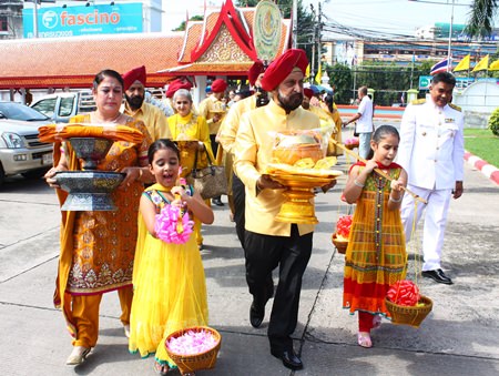 Mohinder Singh (2nd right) and Savinder Kaur Gulati (left) and their family bring the Thod Kathin robes from home to Wat Chaimongkol.