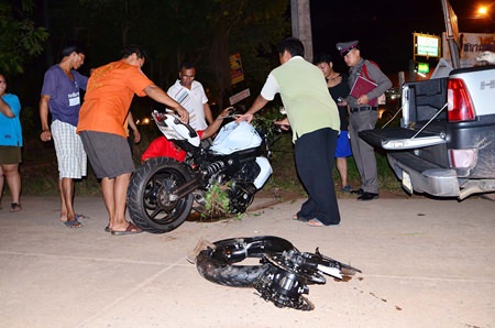 Police and rescue workers remove what is left of the motorcycle.