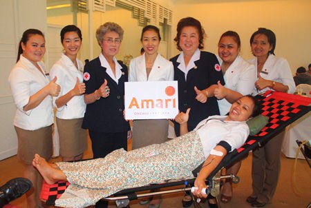 Latiporn Tongkhunna (center), executive assistant manager of Amari Orchid Pattaya, with employees and members of Banglamung Red Cross give thumbs up to donating blood for the Queen Savang Vadhana Hospital.