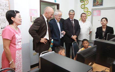 French Ambassador Thierry Viteau (center, holding water cup) visits a learning room at the orphanage.