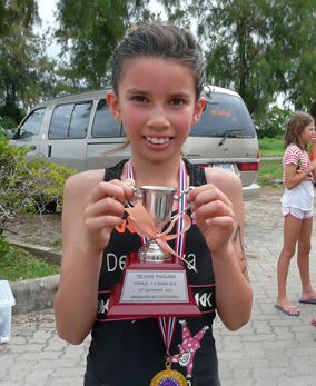 8-year old Sarah-Michelle Clear poses with her trophy after completing the Tri Kids Triathlon in Bangkok, Sunday, Sept. 15.