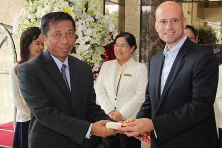 Dominique Ronge (right), general manager of Centara Grand Phratamnak Pattaya, presents a hand garland to Admiral Taweewuth Pongsapipatt (left), Chief of Staff, Royal Thai Navy on his arrival to stay at the newly opened resort as the first guest.