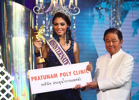 Senator Sutham Phanthusak (right), Managing Director of Tiffany’s Show Pattaya Co., Ltd., presents the top award to Miss International Queen 2013 Marcelo Ohio.