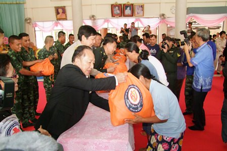 Rajawongse Somlap Kittiyakorn, secretary to HRH Princess Soamsawalee presents disaster relief bags to Panthong residents at Khok Kheenon Temple.