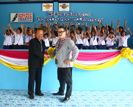 Children show off the rock ‘n’ roll symbol to thank Jorge Carlos Smith (right), General Manager of Hard Rock Hotel Pattaya & Hard Rock Cafe Pattaya, shown here shaking hands with Viroj Ampornvichai (left), director of Huay Yai School, during the presentation of the new canteen.