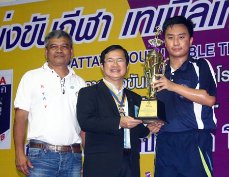 Jamlong Passara (left), former president, and Father Pichan Jaiseri (center), president of Rotary Pattaya, present the winning award to U-18 champion Khamron Hiranyasiri from the Pattaya Sports Club.