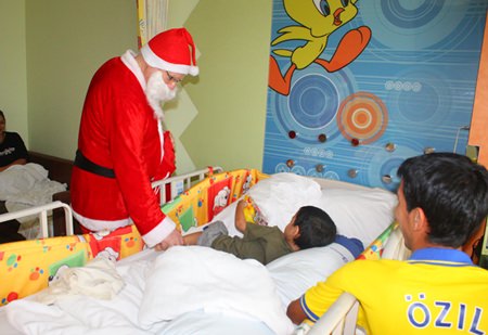 Santa Claus visits a young patient at Bangkok Hospital Pattaya to give him some gifts and lift his spirits.
