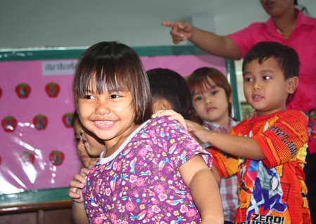 Children smiling, happy, waiting in line for their check-up.