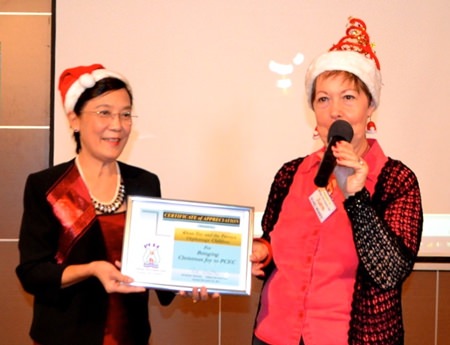 PCEC Treasurer Judith presents Toy with a Certificate of Appreciation from PCEC for her work for the Pattaya Orphanage, and for the inspiring presentation by the children.